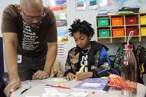 Student getting assistance from teacher on spelling words